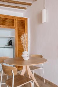 a dining room with a wooden table and chairs at Esquerdo 22 by Seaward Suites in Villajoyosa