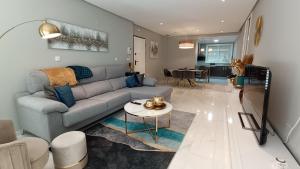 ein Wohnzimmer mit Sofa und Tisch in der Unterkunft Casita Luxury- Grecia 3- Precioso apartamento en Hacienda del Alamo in Los Guerreros