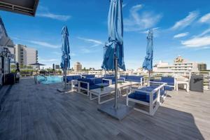 een patio met blauwe stoelen en parasols op een dak bij Spacious Studio Rooftop Pool & Bar with Ocean View in Miami Beach +10 foto's