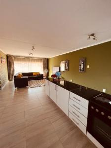 a large kitchen with a living room with a couch at Mama R's 48 in Newcastle