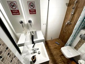 a bathroom with a sink and a toilet and a mirror at Zuzia Apartment - 50 m od Rynku in Racibórz