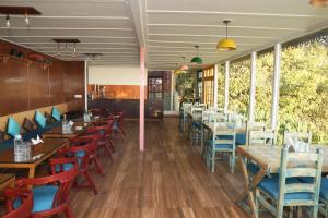 a dining room with wooden tables and chairs at Sansa By The Woods - Manor&Spa in Mussoorie