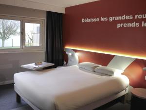 a hotel room with a large white bed and a window at ibis Styles Beauvais in Beauvais