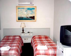 a hotel room with two beds and a tv at Alpes Hotel in Punta del Este