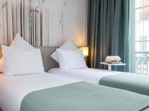 Postel nebo postele na pokoji v ubytování Mercure Paris Montparnasse Raspail