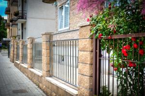 a fence in front of a building with red roses at Apartamenty Wieniawa in Lublin