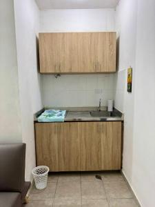 a kitchen with wooden cabinets and a sink at Apartaestudio Rodadero Santa marta in Santa Marta