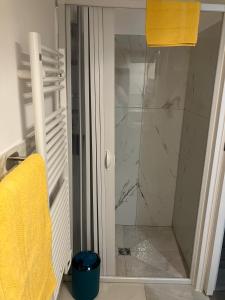 a shower with a glass door and a yellow towel at L'angolo dei mestieri in Perugia