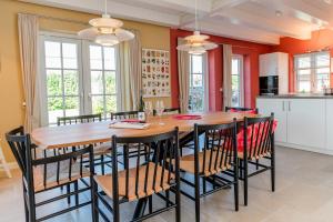 a kitchen and dining room with a wooden table and chairs at Hummerklippen a in Süderende