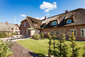 a large brick house with a thatched roof at Hummerklippen a in Süderende