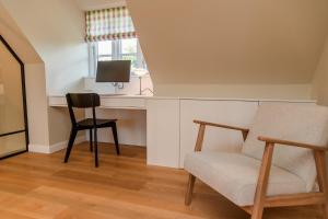 a living room with a chair and a desk at Hummerklippen b in Süderende