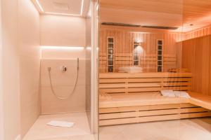 a walk in shower with a glass door in a bathroom at Hummerklippen b in Süderende +43 photos