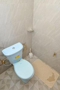 a bathroom with a blue toilet and a shower at Two Bedroom Free Wi-Fi and Netflix in Nanyuki on your way to Ol Pejeta Conservancy in Nanyuki +15 photos