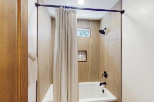 a bathroom with a shower curtain and a sink at Wandering Pine Retreat in Show Low +18 photos