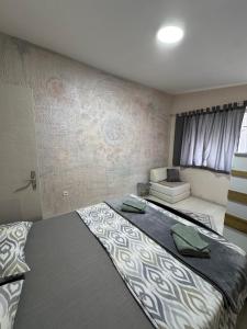 a bedroom with a large bed and a couch at Stan na dan Break in Bačka Palanka
