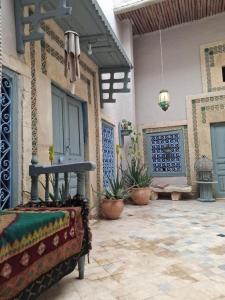 un cortile di una casa con un letto e piante in vaso di Kenza a Sousse