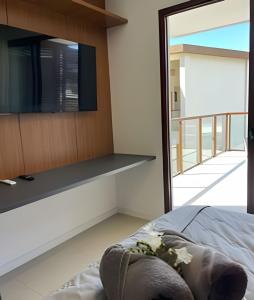 a bedroom with a flat screen tv on a wall at MAR DÁ LIBERDADE com Amerigo Vespucci in Morro de São Paulo