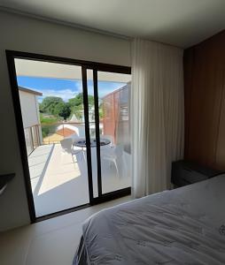 a bedroom with a bed and a view of a balcony at MAR DÁ LIBERDADE com Amerigo Vespucci in Morro de São Paulo +255 photos