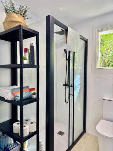 a bathroom with a shower and a black shelf at Casa Rural Madrid Pantano San Juan con Piscina y BBQ in Navahondilla