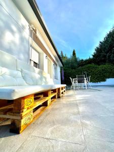 a patio with a bed and a table and chairs at Casa Rural Madrid Pantano San Juan con Piscina y BBQ in Navahondilla