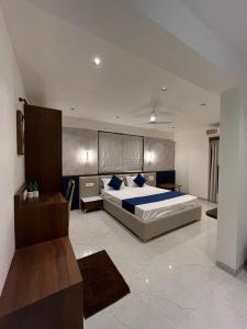 a bedroom with a large bed with blue pillows at Hotel Sai Residency in Pune +20 photos