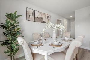 a white dining room with a white table and chairs at Nr Nrg Med Center Hot Tub Bbq Games Swing Set in Houston