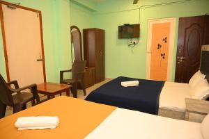 a hotel room with two beds and a table and chairs at ROYAL SEAVIEW RESIDENCY in Port Blair