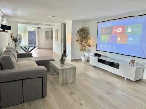 a living room with a large flat screen tv at Casa Rural Madrid Pantano San Juan con Piscina y BBQ in Navahondilla