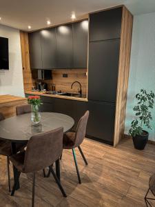 a kitchen and dining room with a table and chairs at Apartmán TatraNest in Nová Lesná