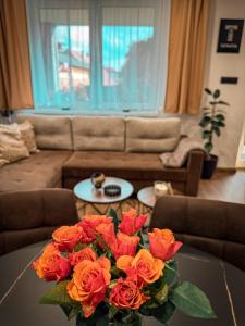 a vase of roses on a table in a living room at Apartmán TatraNest in Nová Lesná