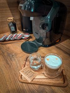 a coffee maker and a glass of water on a cutting board at Apartmán TatraNest in Nová Lesná +59 photos
