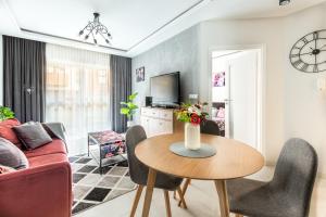 a living room with a red couch and a table at Apartament GB przy PCK 3A z bezpłatnym parkingiem by Gingerbread Apartments in Toruń