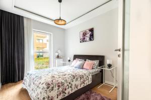 a bedroom with a bed and a window at Apartament GB przy PCK 3A z bezpłatnym parkingiem by Gingerbread Apartments in Toruń
