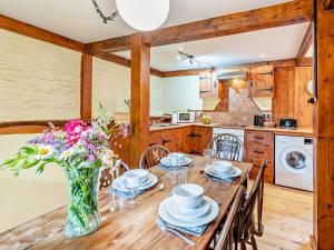 a kitchen with a wooden table with a vase of flowers at 2 bed in Ilfracombe MALTC in West Down +15 photos