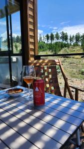 a glass of wine sitting on a table at Brisas de la Cayana Cabaña Villa Alpina in Villa Alpina
