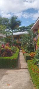 a sidewalk in front of a building with a garden at Casa palmera in San Juan del Sur