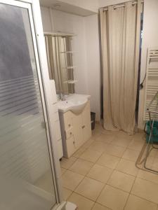 ein Badezimmer mit einem weißen Waschbecken und einer Dusche in der Unterkunft Appartement rez de chaussé 60m2 in Montreuil-sur-Ille