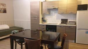 eine Küche mit einem Tisch und eine Küche mit einem Kühlschrank in der Unterkunft Appartement rez de chaussé 60m2 in Montreuil-sur-Ille