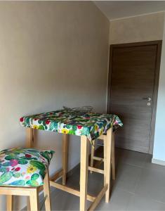 una mesa y dos taburetes en una habitación en Appartamento Campo grande, en Cavallino di Lecce