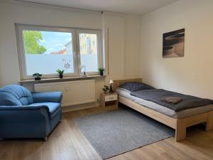 ハッタースハイムにあるModern Stay Hattersheim with four bedroomsのベッドと椅子と窓のある寝室