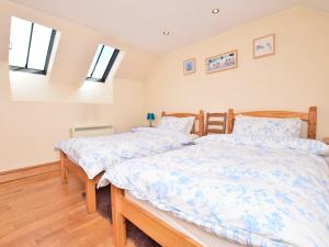 Dos camas en un dormitorio con dos ventanas. en 2 Bed in Dunster 41218, en Timberscombe