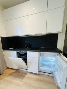 a kitchen with white cabinets and an open dishwasher at Apartment with parking Brno Komín in Komín
