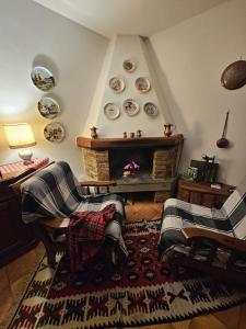Mountain home with sauna في سوتريو: غرفة معيشة مع كرسيين ومدفأة