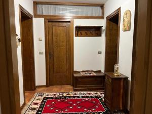 Mountain home with sauna في سوتريو: ممر فيه باب وسجادة حمراء