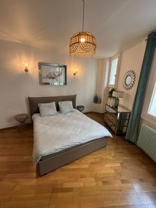 een slaapkamer met een bed en een kroonluchter bij Appartement Tour Eiffel Marois in Parijs