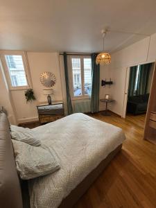 een slaapkamer met een bed, een tafel en ramen bij Appartement Tour Eiffel Marois in Parijs +16 foto's
