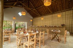 a dining room with wooden tables and chairs at Villa Tapi in Jericoacoara