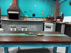 a kitchen with a table in the middle of it at Pousada Dorcas in Ubatuba