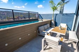 a balcony with a swimming pool and a table and chairs at Naomi Boutique Villa with private pool in Netu'a