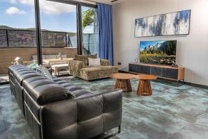 a living room with a couch and a tv at Naomi Boutique Villa with private pool in Netu'a